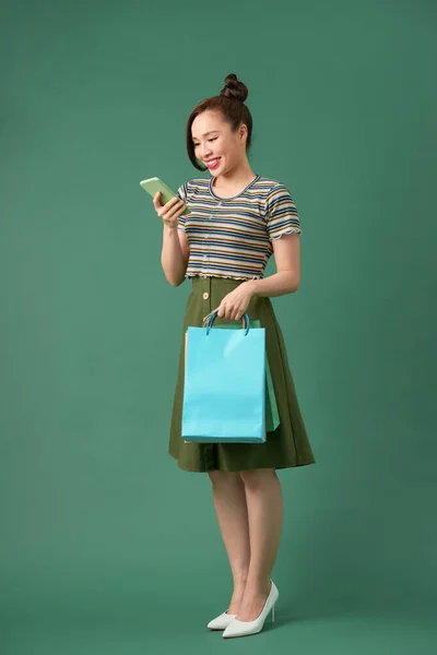 Χαρούμενο Κομψό Κορίτσι Κρατώντας Τσάντες Ψώνια Ενώ Κουβεντιάζοντας Στο Smartphone — Φωτογραφία Αρχείου