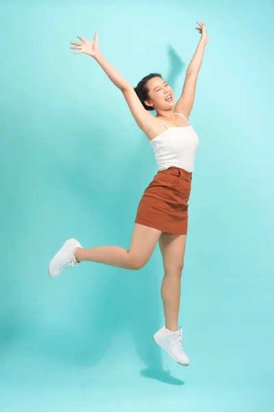 Image of emotional young lady jumping isolated over white background wall.