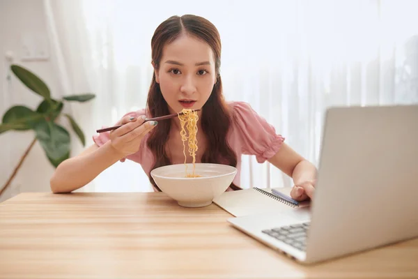 Νεαρή Ασιάτισσα Που Χρησιμοποιεί Φορητό Υπολογιστή Ενώ Τρώει Νουντλς Στο — Φωτογραφία Αρχείου