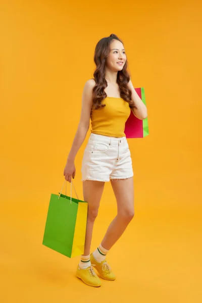 ショッピングバッグを手にした美しいファッショナブルな魅力的な女性がお店を歩く — ストック写真