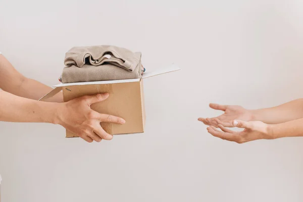 手握盒把衣服放在一起进行概念捐赠和重复使用 — 图库照片