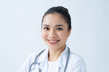 Mesajınız için arka planda gülümseyen Asyalı genç bayan doktor portresi.