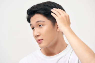 Saçlarını parmaklarıyla tarayan sağlıklı bir adamın portresi.