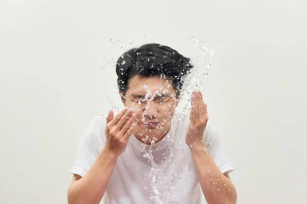 Young Man Spraying Water His Face White Background — Stock Photo, Image