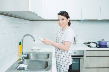 Önlük giymiş bir kadın, mutfak, yemek pişirme.