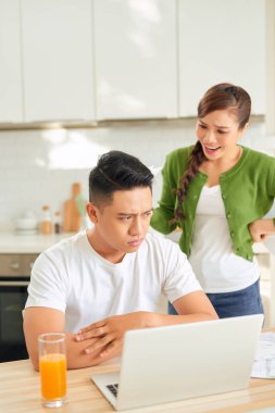 Finansal faturaları olan üzgün genç bir kadın evde bir erkekle kavga ediyor.