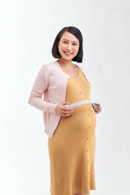 Hamile kadın bebeğine müzik gösteriyor.