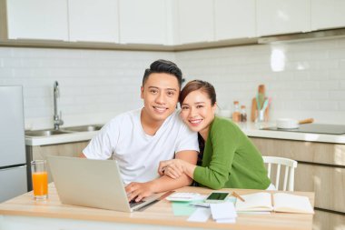 Kadın ve erkek birlikte evrak işi yapıyor, vergilerini internet üzerinden ödüyor.