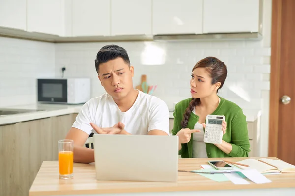 Upset young couple with financial bills having conflict in home interior
