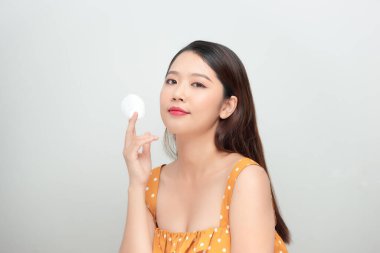 Sağlıklı kız pamukla makyajını temizliyor.