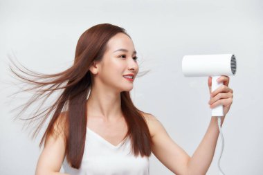 Komik kız yeni yıkanmış saçlarını kurutuyor ve aynaya bakıyor.