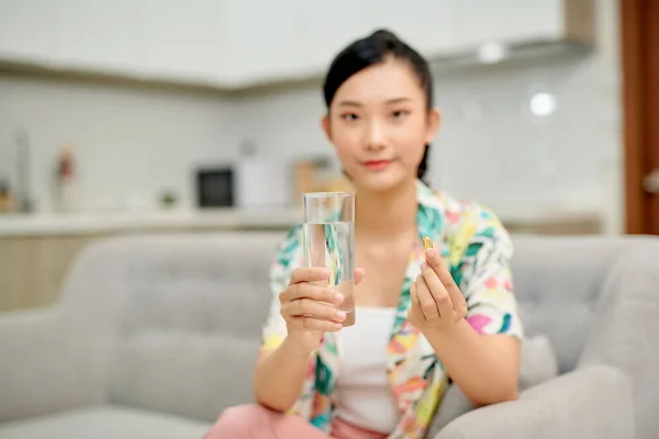 Mulher Feliz Tomando Uma Pílula Vitamina Amarela Sentada Sofá Sala — Fotografia de Stock