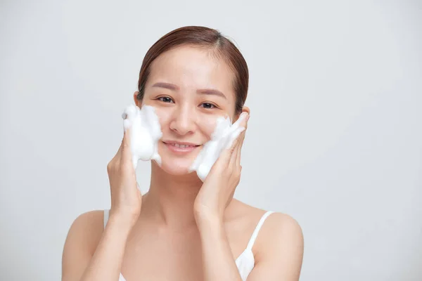 陽気なアジアの女性は 泡のクレンザーを適用し きれいな新鮮な健康的な肌を持っています — ストック写真