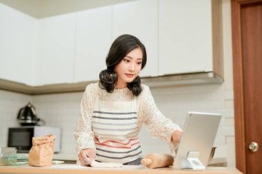 Pozitif genç kız hamurla çalışıyor ve gülümsüyor