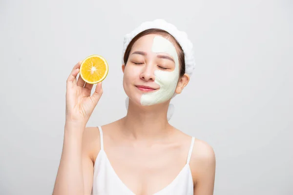 Gelukkig Jong Aziatisch Vrouw Met Gezicht Klei Masker Holding Oranje — Stockfoto