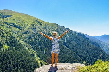 Transfegerasan dağ yolunun yanındaki uçurumun kenarındaki kız..