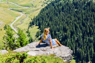 Transfegerasan dağ yolunun yanındaki uçurumun kenarındaki kız..