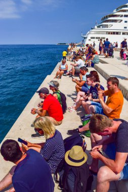 Zadar, Hırvatistan - 6 Temmuz 2018: Turist dinle müzik deniz organ Promenade