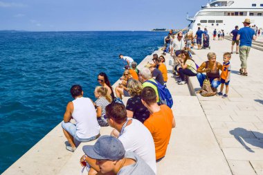 Zadar, Hırvatistan - 6 Temmuz 2018: Turist dinle müzik deniz organ Promenade.