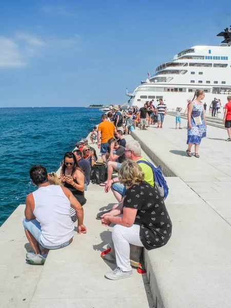 Zadar, Hırvatistan - 6 Temmuz 2018: Turist dinle müzik deniz organ Promenade.