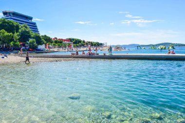 Vodice, Hırvatistan - 8 Temmuz 2018: Tatilcilerin güzel çakıl plaj.