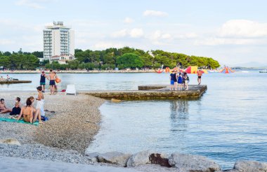 Vodice, Hırvatistan - 9 Temmuz 2018: Tatilcilerin güzel çakıl plaj.