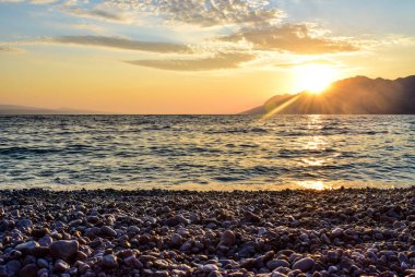 Denizin üzerinde gün batımı.