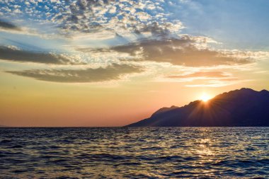 Denizin üzerinde gün batımı.