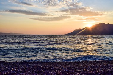 Denizin üzerinde gün batımı.