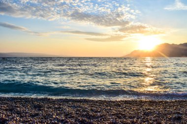 Denizin üzerinde gün batımı.