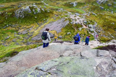 Kjerag, Norveç - 18 Haziran 2019: Dünyanın en tehlikeli taşı olan Kjeragbolten yolunda yürüyen turistler. Kjeragbolten Lysefjorden 'dan 984 metre yükseklikte sıkışmış bir kaya..