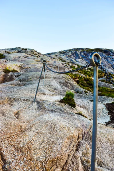 Chains on pathway to famous Kjeragbolten to help go up on climb steep cliffs. Kjeragbolten is a rock stuck between two mountains above Lysefjorden on mountain Kjerag in Forsand municipality, Norway.