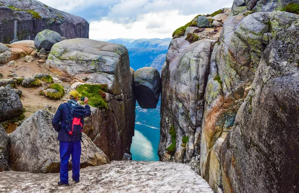 游客给世界上最危险的石头拍了一张照片 Kjeragbolten是位于挪威Kjerag山上Lysefjorden上空984米的岩石 — 图库照片