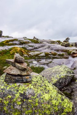 Kjeragbolten yolu. Norveç dağlarının manzaraları, Norveç 'in Kjerag Dağı' ndaki Lysefjorden 'ın 984 metre üstünde dünyanın en tehlikeli taşının bulunduğu yer..