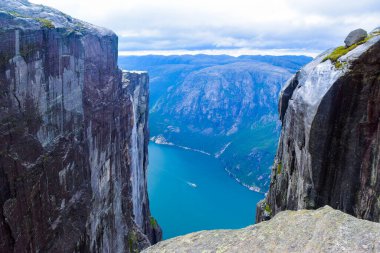 Lysefjorden 'ın 984 metre yüksekliğindeki iki uçurum arasındaki yarıktan görünüşü, ünlü Kjeragbolten' in dünyanın en tehlikeli taşı yakınlarda sıkışıp kaldığı yer. Kjerag Dağı, Rogaland Bölgesi, Norveç.