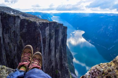 Lysefjorden 'ın muhteşem dağ manzarası mavi suya yansıyan bulutlarla. Kjerag Platosu 'ndan görüntü, 984 metre yükseklikte Kjeragbolten' in iki kayasının arasına sıkışmış. Norveç.