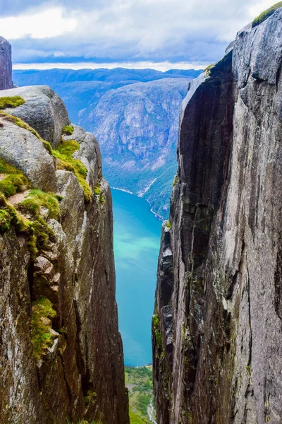 View of Lysefjorden through a crevice between two cliffs 984 meters high, where the famous Kjeragbolten stuck nearby - the most dangerous stone in the world. Mountain Kjerag, Rogaland county, Norway.