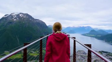 Rampestreken yürüyüşü. Rampestreken Viewpoin 'deki turist kız. Panoramik manzara Andalsnes şehri Romsdal Fjord kıyılarında, pitoresk dağlar arasında yer alır. Ve tuzaklar. Norveç.
