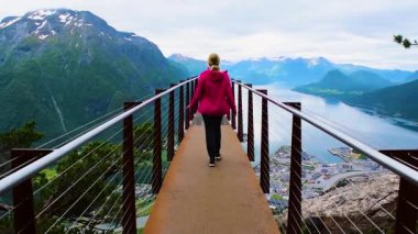 Rampestreken yürüyüşü. Rampestreken Viewpoin 'deki turist kız. Panoramik manzara Andalsnes şehri Romsdal Fjord kıyılarında, pitoresk dağlar arasında yer alır. Ve tuzaklar. Norveç.