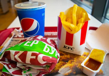 Kiev, Ukrayna - 8 Mart 2020: Popüler bir fast food restoranı olan KFC 'de yiyecek ve içecek. Kentucky Fried Chicken olarak bilinen popüler fast food zinciri. Patates kızartması, Pepsi ve köri soslu burger..
