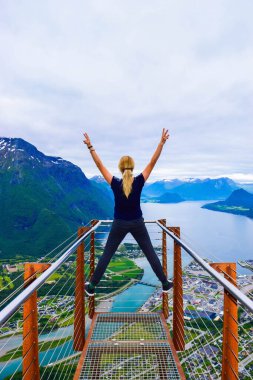 Rampestreken yürüyüşü. Rampestreken Viewpoin 'deki turist kız. Panoramik manzara Andalsnes şehri Romsdal Fjord kıyılarında, pitoresk dağlar arasında yer alır. Ve tuzaklar. Norveç
