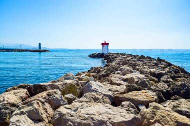 Yat limanının girişini koruyan dalgakıranların kayalıklarında bulunan iki deniz feneri. Sakin deniz ve mavi gökyüzünün yaz manzarası. Villeneuve-Loubet. Gökyüzü Sahili, Fransız Rivierası.