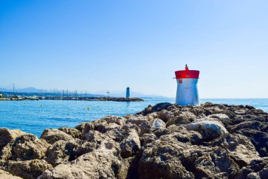 Yat limanının girişini koruyan dalgakıranların kayalıklarında bulunan iki deniz feneri. Sakin deniz ve mavi gökyüzünün yaz manzarası. Villeneuve-Loubet. Gökyüzü Sahili, Fransız Rivierası.