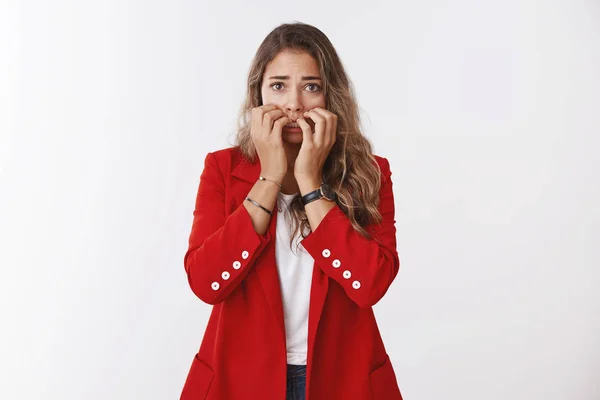 Girl scared tell boss truth. Worried panicking caucasian woman wearing red jacket, biting fingernails nervously, looking afraid, shaking fear, trembling terrified, being victim, facing abuse