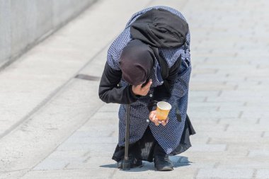 Yaşlı dilenci kadın eğilmiş bir yaya bölgesinde, Almanya