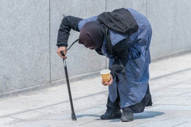 Yaşlı dilenci kadın eğilmiş bir yaya bölgesinde, Almanya