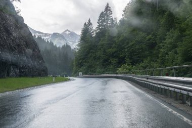 Yağmurlu yol yüzeyi ve bir araba ön cam üzerinde yağmur damlaları