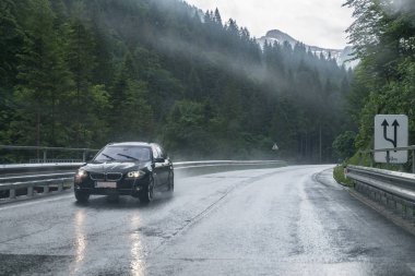 Yağmurlu yol yüzeyi ve bir araba ön cam üzerinde yağmur damlaları