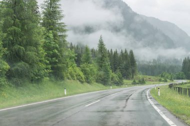 Yağmurlu yol yüzeyi ve bir araba ön cam üzerinde yağmur damlaları