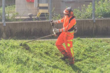 Bahçıvan bir pil Çim düzeltici, Almanya bir kasabada bir set of çim biçme